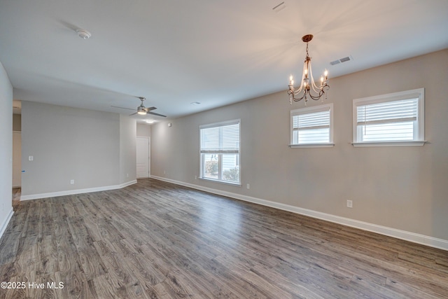 spare room featuring wood-type flooring and ceiling fan with notable chandelier