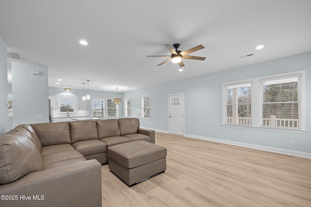 living room featuring ceiling fan and light wood-type flooring