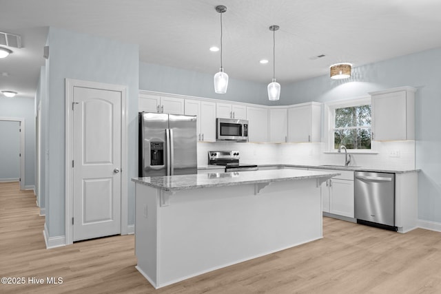 kitchen featuring white cabinetry, sink, a center island, and appliances with stainless steel finishes