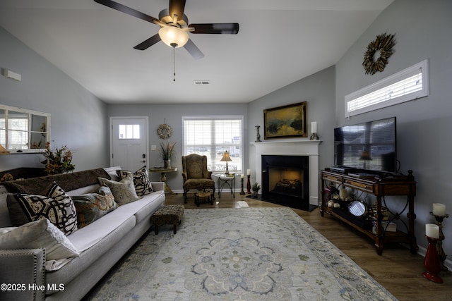 living room featuring dark wood-type flooring, ceiling fan, and high vaulted ceiling