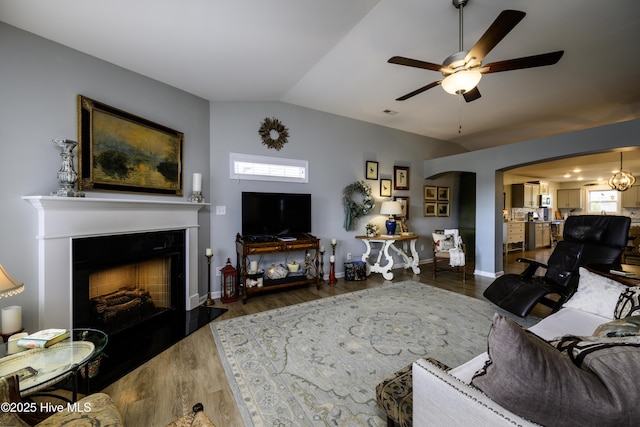 living room featuring vaulted ceiling, dark hardwood / wood-style floors, a wealth of natural light, and ceiling fan