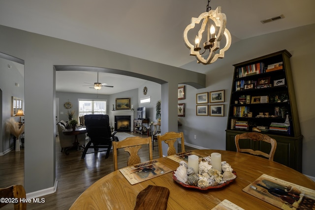 dining room featuring dark wood-type flooring and ceiling fan with notable chandelier