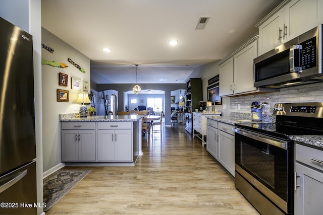 kitchen with appliances with stainless steel finishes, decorative light fixtures, decorative backsplash, and gray cabinetry