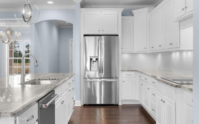 kitchen featuring appliances with stainless steel finishes, white cabinetry, sink, hanging light fixtures, and light stone countertops