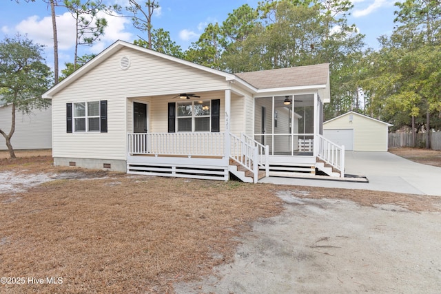 view of front facade featuring a garage, an outbuilding, ceiling fan, covered porch, and a sunroom