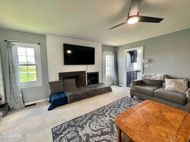 living room with ceiling fan and carpet