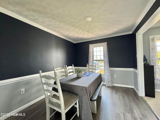 dining room featuring hardwood / wood-style floors, crown molding, and a wealth of natural light