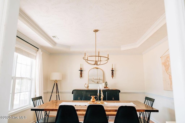 dining room with a raised ceiling, crown molding, a notable chandelier, and a textured ceiling