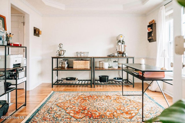 office space with crown molding, a tray ceiling, and light hardwood / wood-style floors