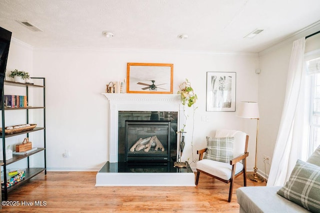 living area featuring wood-type flooring and ornamental molding