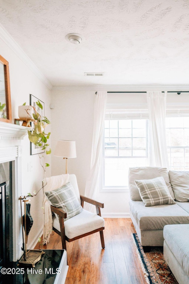 living room featuring ornamental molding, hardwood / wood-style floors, and a textured ceiling