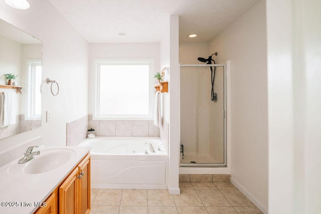 bathroom featuring vanity, plus walk in shower, tile patterned flooring, and a wealth of natural light