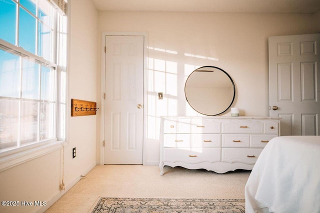 bedroom with multiple windows and light colored carpet