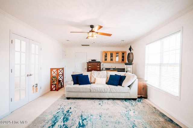 living room featuring light carpet, ornamental molding, and ceiling fan