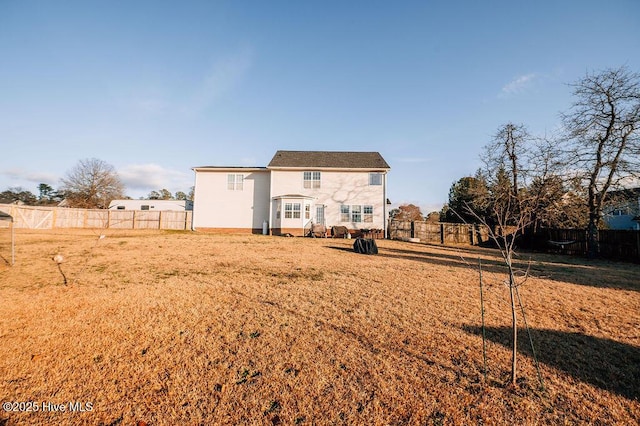 rear view of property featuring a lawn