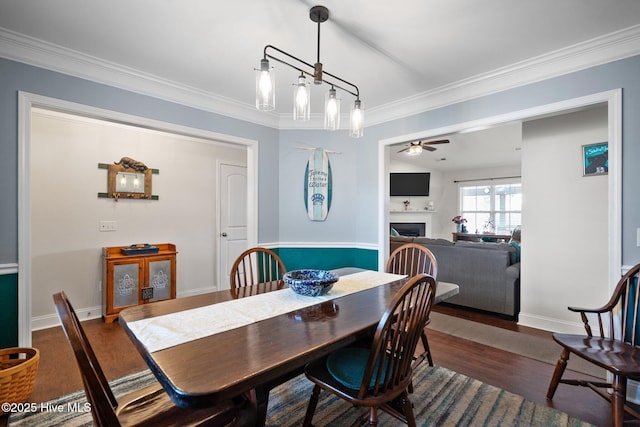 dining room with crown molding, ceiling fan, and dark hardwood / wood-style flooring