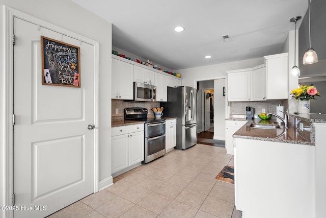 kitchen with white cabinetry, sink, decorative light fixtures, and appliances with stainless steel finishes