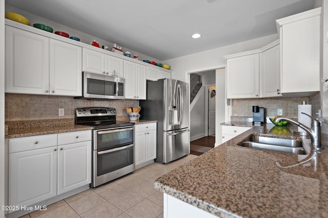 kitchen featuring stainless steel appliances, tasteful backsplash, sink, and white cabinets