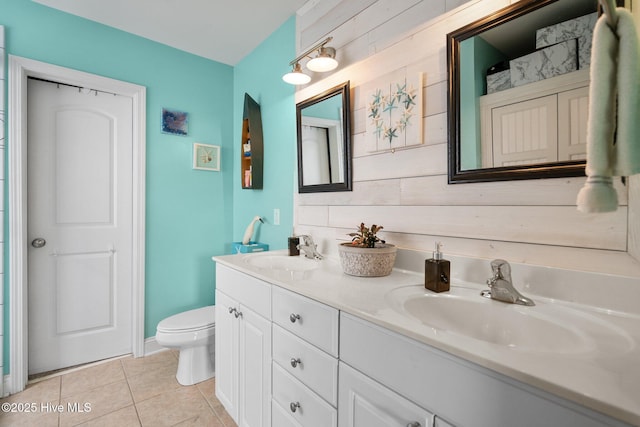 bathroom featuring wooden walls, vanity, toilet, and tile patterned flooring