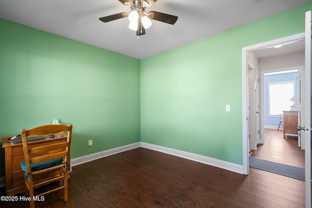 spare room with dark wood-type flooring and ceiling fan