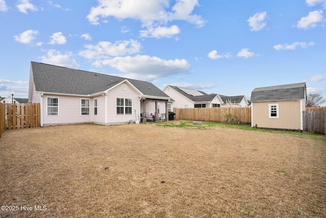 back of house with a shed and a lawn