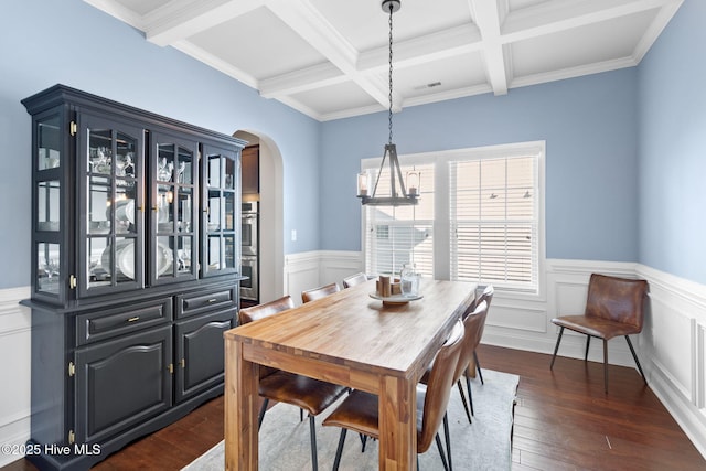 dining space with beamed ceiling, coffered ceiling, dark hardwood / wood-style flooring, and a chandelier