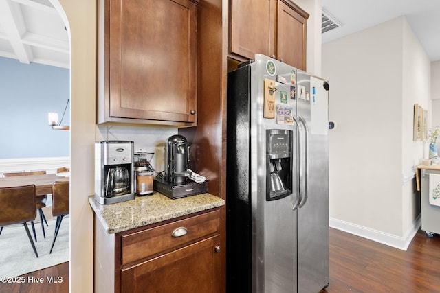 kitchen featuring dark hardwood / wood-style floors, coffered ceiling, light stone counters, stainless steel refrigerator with ice dispenser, and beam ceiling