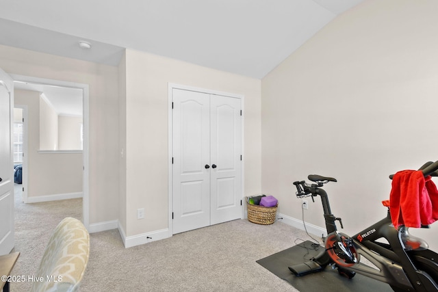 exercise area with light carpet and vaulted ceiling