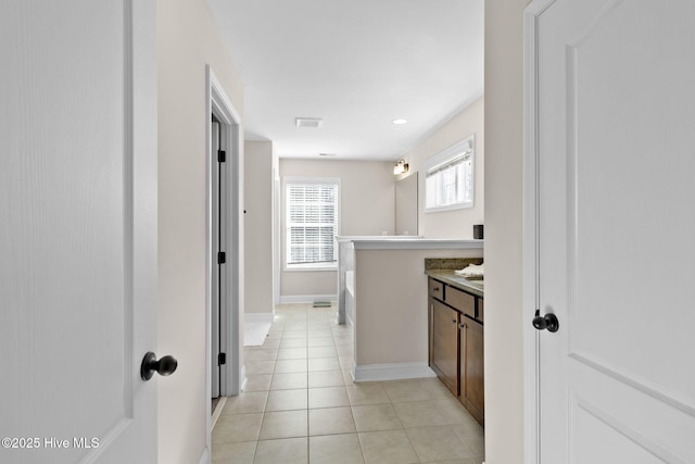 bathroom featuring vanity, a washtub, and tile patterned floors