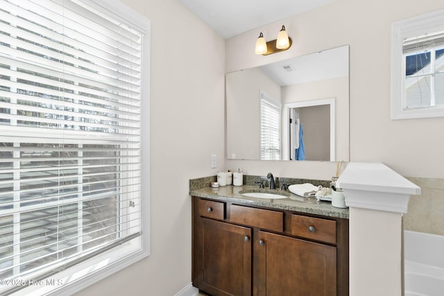 bathroom featuring vanity and a tub