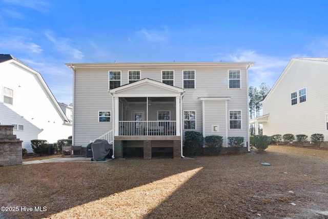 rear view of house featuring a sunroom and a patio area