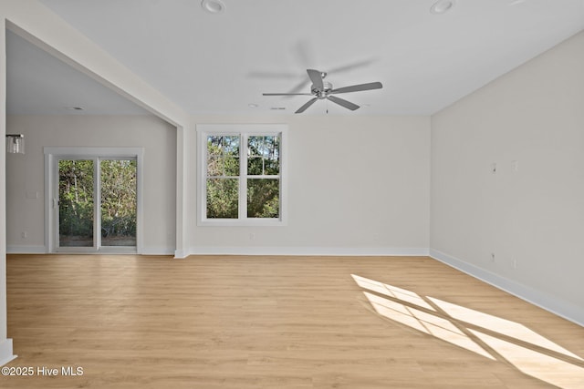 unfurnished room featuring a wealth of natural light, ceiling fan, and light wood-type flooring