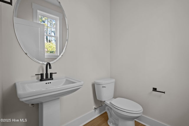 bathroom with hardwood / wood-style flooring and toilet