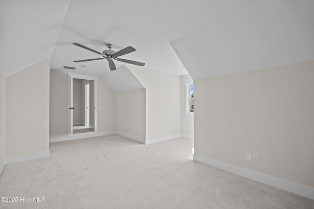 additional living space featuring lofted ceiling, light carpet, and ceiling fan