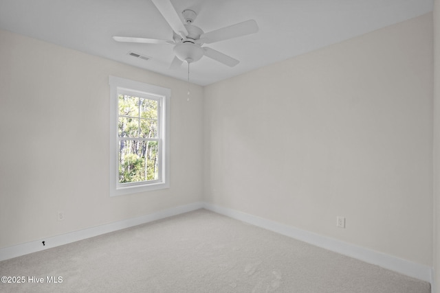 carpeted spare room featuring ceiling fan