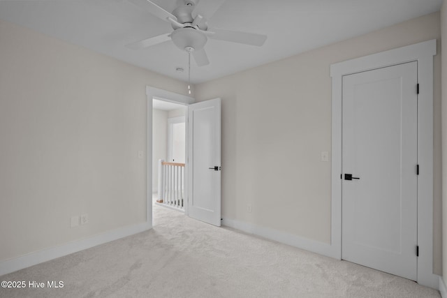 unfurnished bedroom with ceiling fan and light carpet