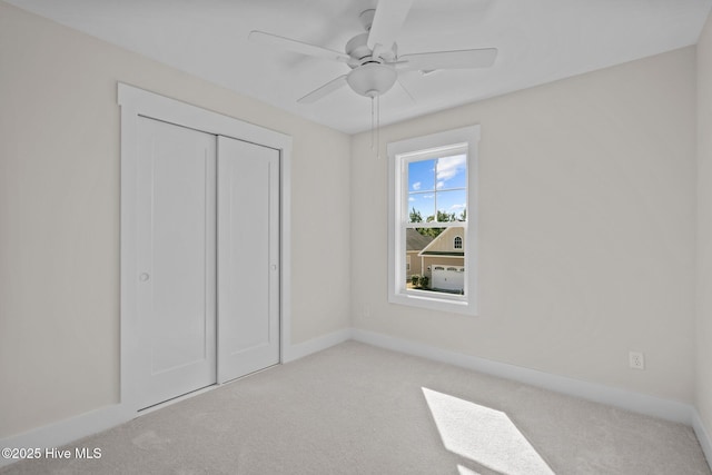 unfurnished bedroom featuring light carpet, ceiling fan, and a closet