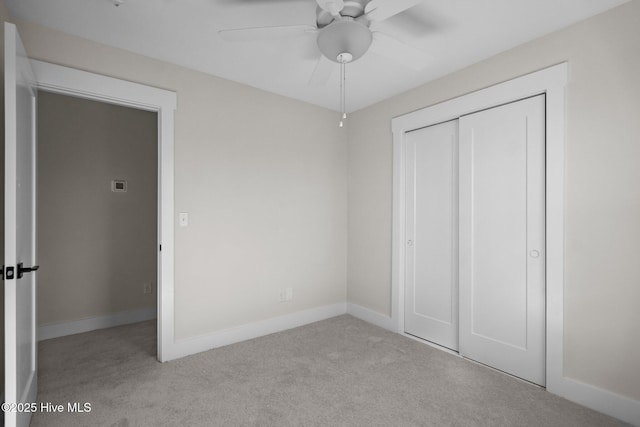 unfurnished bedroom with light carpet, a closet, and ceiling fan