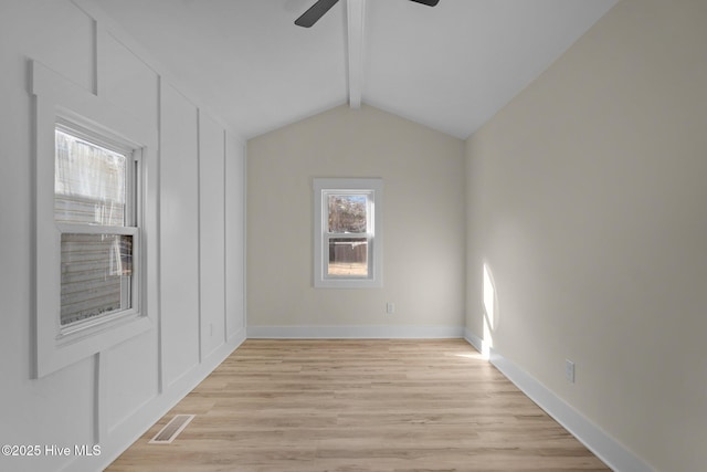 unfurnished room featuring ceiling fan, light hardwood / wood-style floors, and vaulted ceiling with beams