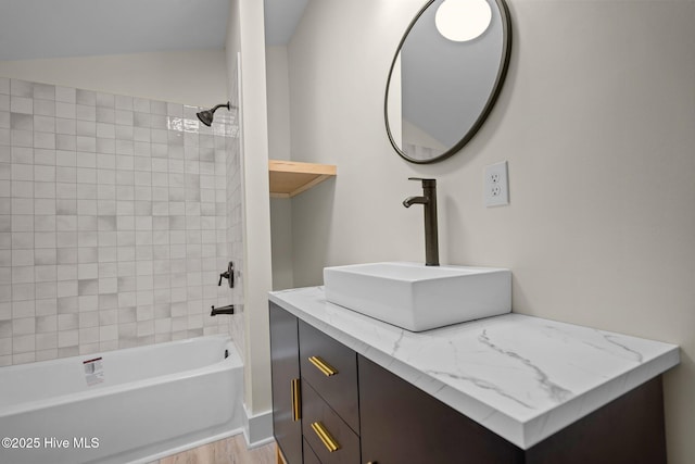 bathroom featuring vanity, tiled shower / bath combo, and wood-type flooring