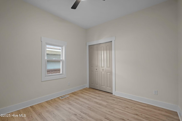 unfurnished bedroom featuring a closet, ceiling fan, and light hardwood / wood-style flooring