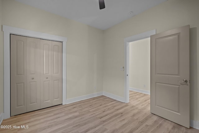 unfurnished bedroom with light hardwood / wood-style floors, a closet, and ceiling fan