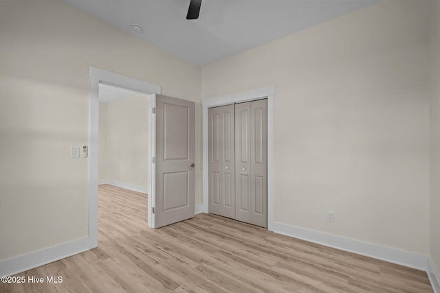 unfurnished bedroom featuring light hardwood / wood-style floors, a closet, and ceiling fan