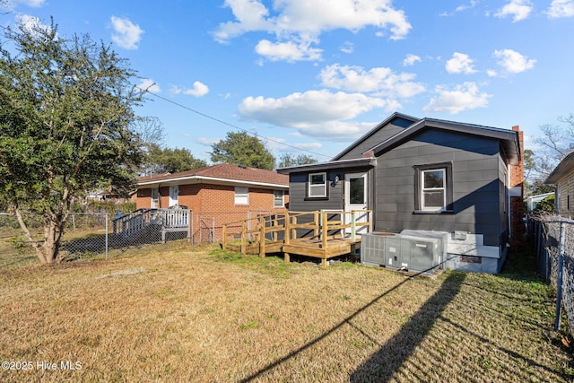 back of house with a wooden deck and a lawn