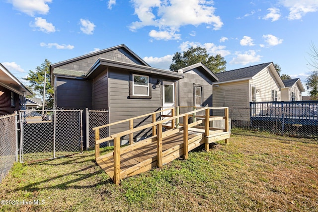 rear view of property with a yard and a deck