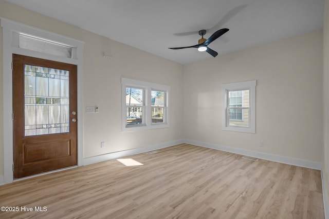 entrance foyer with ceiling fan, a wealth of natural light, and light wood-type flooring