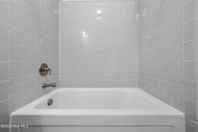 bathroom featuring tiled shower / bath