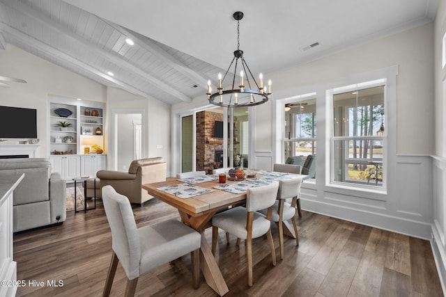 dining room featuring built in shelves, a fireplace, dark wood-type flooring, and vaulted ceiling with beams