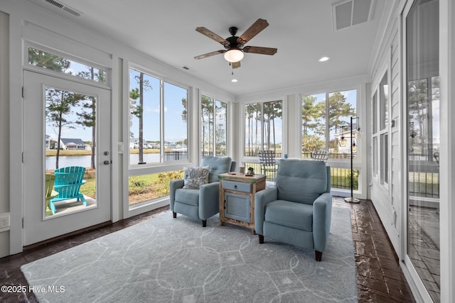 sunroom featuring a water view and ceiling fan