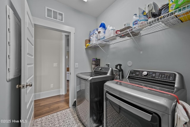 laundry room with washer and dryer and hardwood / wood-style floors